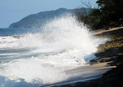 a wave in the water on a beach at Villa Ethir in Tamarindo