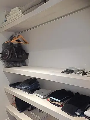 a walk in closet with white shelves and clothes at Villa Ethir in Tamarindo