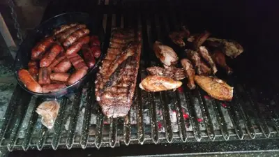 a grill with a bunch of different types of meat at Mountain Lodge CheTica in San Jerónimo