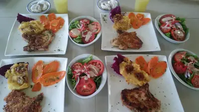 a group of plates of food with tomatoes and vegetables at Mountain Lodge CheTica in San Jerónimo