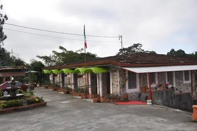 a building with a flag on top of it at Mountain Lodge CheTica in San Jerónimo
