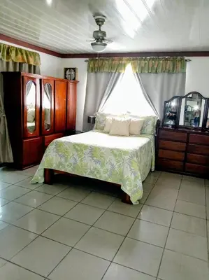 a bedroom with a large bed and a window at Villa Guarias in Puntarenas