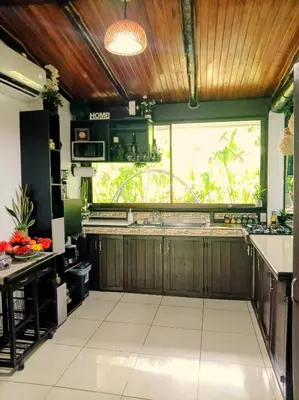 a kitchen with wooden cabinets and a large window at Villa Guarias in Puntarenas