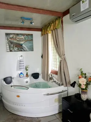 a white tub in a bathroom with a window at Villa Guarias in Puntarenas