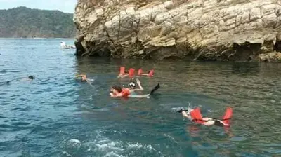a group of people swimming in a body of water at Villa Guarias in Puntarenas
