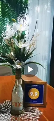 a vase with flowers in it next to a clock at Villa Guarias in Puntarenas