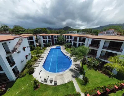 an aerial view of the courtyard of a hotel with a swimming pool at Bahia Azul 2A beachfront, Jaco Beach, 1st floor in Jacó