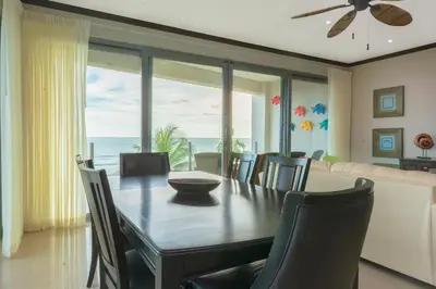 a dining room with a table and a view of the ocean at Diamante del Sol Ocean front condos, Micasas in Jacó