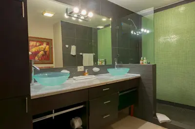 a bathroom with two sinks and a large mirror at Diamante del Sol Ocean front condos, Micasas in Jacó
