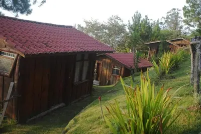 a row of wooden huts in a field at Cabañas Don Camilo Albergue de Montaña in Cabecera de Cañas