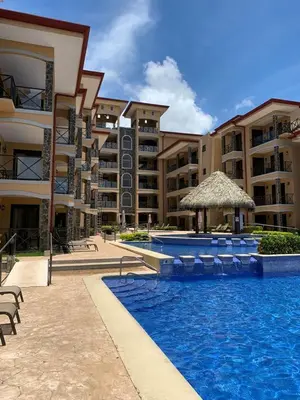 a swimming pool in front of a large apartment building at Bahia Encantada beach front proyect, Micasas in Jacó