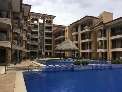 a hotel with a swimming pool in front of a building at Bahia Encantada beach front proyect, Micasas in Jacó