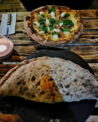 two pizzas sitting on top of a wooden table at Nature house in Monteverde Costa Rica
