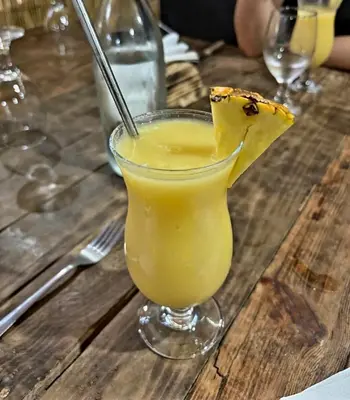 a glass of orange juice on a wooden table at Nature house in Monteverde Costa Rica
