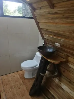 a bathroom with a toilet and a wooden wall at Nature house in Monteverde Costa Rica
