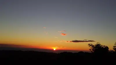 a sunset with the sun in the sky at Nature house in Monteverde Costa Rica