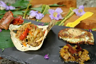 a piece of food on a cutting board with food at Hotel Tropico Latino in Santa Teresa Beach