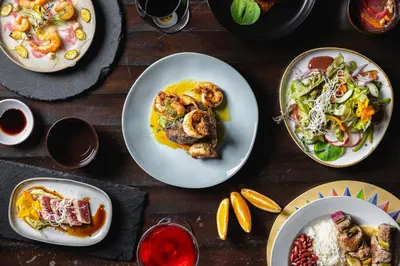 a wooden table with plates of food on it at Villa Blanca Cloud Forest Hotel & Retreat in San Ramón