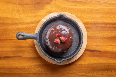 a chocolate dessert in a pan on a wooden table at Villa Blanca Cloud Forest Hotel & Retreat in San Ramón