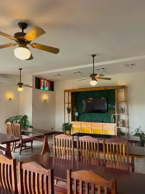 a dining room with a table and chairs and a tv at Villa Blanca Cloud Forest Hotel & Retreat in San Ramón