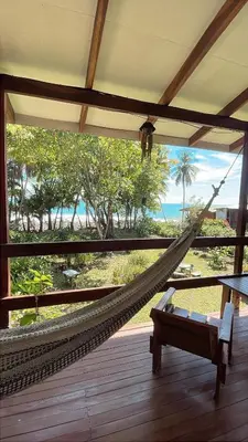 a hammock on a porch with a view of the ocean at El Pargo Feliz in Montezuma