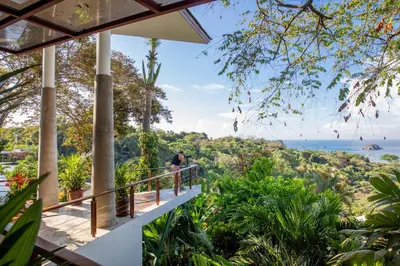 a balcony of a house with a view of the ocean at Si Como No Resort & Wildlife Refuge in Manuel Antonio