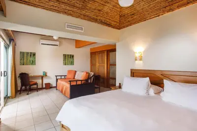 a bedroom with a bed and a living room at Si Como No Resort & Wildlife Refuge in Manuel Antonio