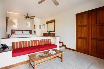 a living room with a red couch and a bed at Si Como No Resort & Wildlife Refuge in Manuel Antonio