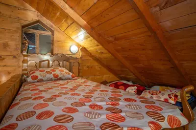 a bedroom with a bed in a wooden attic at Cabaña de montaña La Magnolia, Cerro de la Muerte De La Cañuela Cloud Forest in Tres de Junio