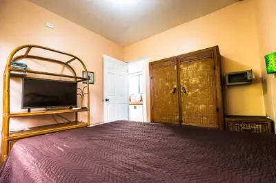 a bedroom with a large bed and a tv at La Dolce Vita in Esterillos