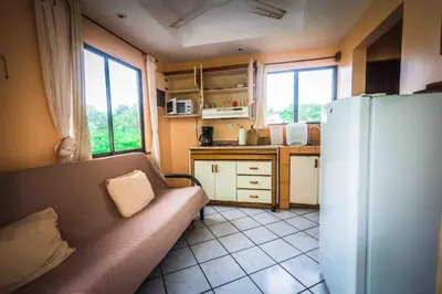 a kitchen with a couch and a refrigerator at La Dolce Vita in Esterillos