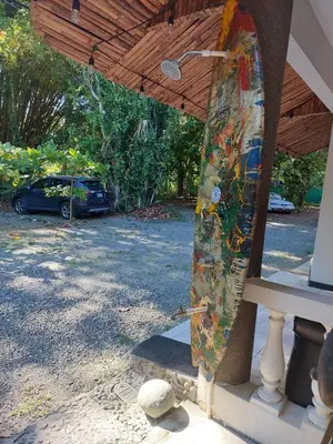a surfboard is standing under a roof at Casa Arenas in Manuel Antonio