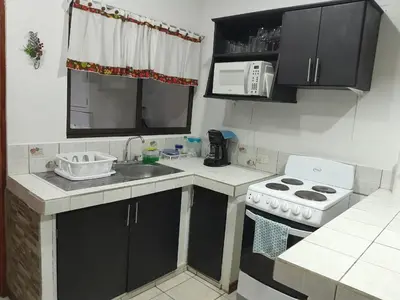 a small kitchen with a sink and a stove at Casa Arenas in Manuel Antonio