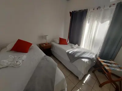 a bedroom with two beds and a window at Casa Arenas in Manuel Antonio