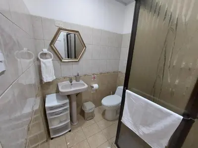 a bathroom with a sink and a toilet and a mirror at Casa Arenas in Manuel Antonio
