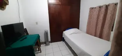 a small hospital room with a bed and a desk at Duerme tranquilo in Alajuela City