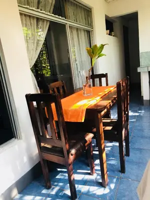 a wooden table with chairs and a vase on top at Duerme tranquilo in Alajuela City