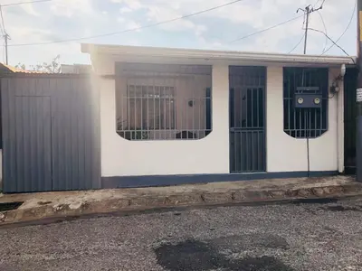 a small white house with a fence at Duerme tranquilo in Alajuela City