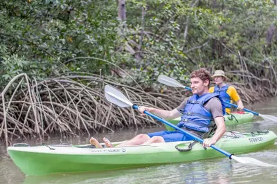 two men in a green kayak on a river at Kayak Lodge in Damas