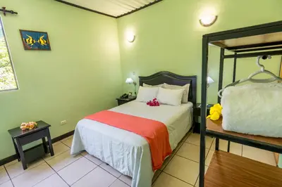 a bedroom with a large bed with a red blanket at Kayak Lodge in Damas