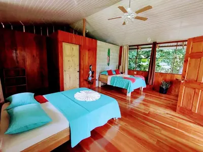 a bedroom with two beds and a ceiling fan at The Sunset Tucano Lodge in Drake