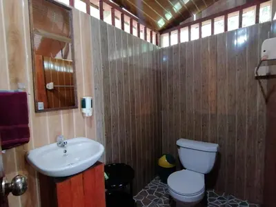 a bathroom with a toilet and a sink at The Sunset Tucano Lodge in Drake