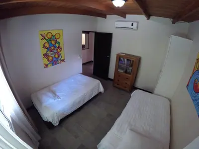 a bedroom with a bed and a dresser in it at The Falls at Manuel Antonio in Manuel Antonio