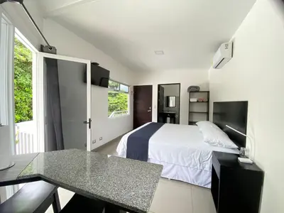 a bedroom with a bed and a table in it at Uvita Paradise in Uvita