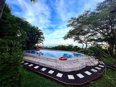 a swimming pool in a yard with trees and grass at Domos Mirador Romantic Private Honeymoon Glamping in Miramar