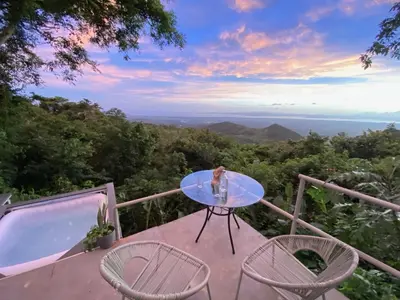 a table and chairs on a balcony with a view at Domos Mirador Romantic Private Honeymoon Glamping in Miramar