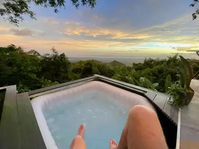 a person laying in a jacuzzi tub with their feet in it at Domos Mirador Romantic Private Honeymoon Glamping in Miramar