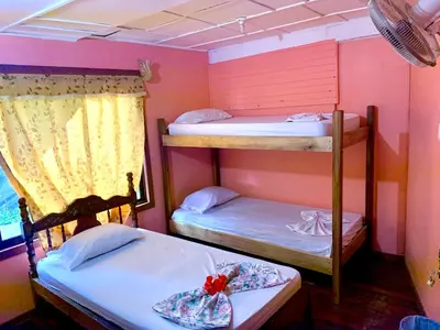 a room with two bunk beds in a room at Pura Vida Hostel in Montezuma