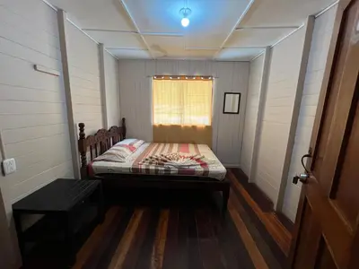 a small room with a bed and a window at Pura Vida Hostel in Montezuma