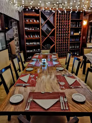 a dining room with a table with chairs and wine bottles at El Establo Mountain Hotel in Monteverde Costa Rica